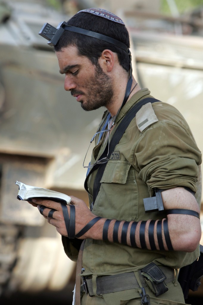 An Israeli soldier wearing tefillin while praying